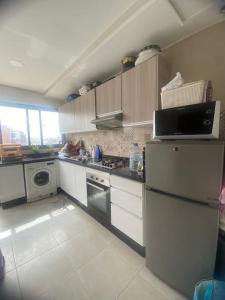 een keuken met een koelkast en een fornuis bij Élégant & Cosy Appartement in Casablanca