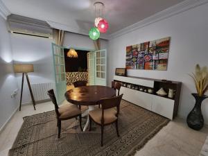 a dining room with a wooden table and chairs at La maison enchantée in Tunis