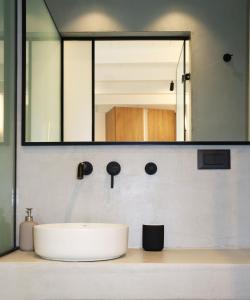 un bagno con un lavandino e un grande specchio di Porto 57 a Chania