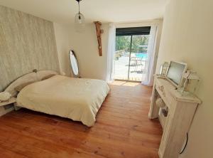 1 dormitorio con 1 cama, TV y ventana en Le domaine du Quercy, en Padirac