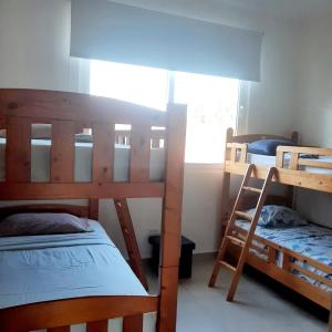Zimmer mit 3 Etagenbetten und einem Fenster in der Unterkunft Rio Mar Villages in San Carlos