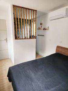 1 dormitorio con cama negra y cocina en Petite villa en bois avec piscine en Montbazin