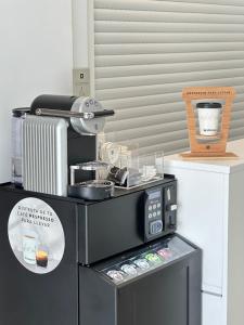 a kitchen with a black microwave and a coffee maker at RAQUEL'S - Habitacions i Apartaments turístics - in Sant Pere Pescador