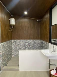 y baño con bañera y lavamanos. en Casablanca Homestay en Āīzawl