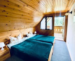 1 dormitorio con 2 camas en una habitación de madera en Zielony Domek, en Ruciane-Nida