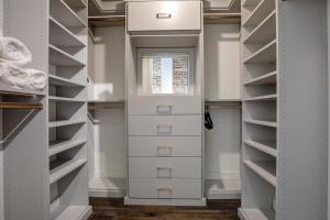 a walk in closet with white cabinets and a window at New Construction Loft Style Spacious Lux Apt in Atlanta