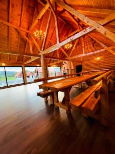 una gran mesa de madera en un edificio con ventanas en Cabana Dzsesszika&Erik, en Kàszonuifalù