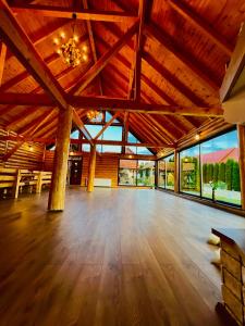 a large room with a wooden floor and large windows at Cabana Dzsesszika&Erik in Kàszonuifalù