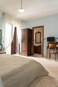 a bedroom with a bed and a dresser and a mirror at B&B Iris in Laterza