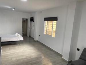 a white room with a bed and a window at Estudios Barbate Playa 4 in Barbate