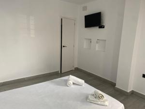 a white room with a bed with towels on it at Estudios Barbate Playa 4 in Barbate +2 photos