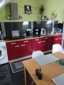 パーペンブルクにあるApartment am Obenendeのキッチン(赤いキャビネット、白い電化製品付)