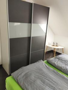 1 dormitorio con 1 cama y pared gris y blanca en Apartment am Obenende, en Papenburg