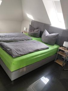 a bed with a green bed frame in a room at Apartment am Obenende in Papenburg