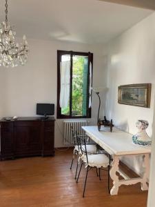 una sala da pranzo con tavolo, sedie e finestra di Venezia Lido Villa Delle Palme a Lido di Venezia
