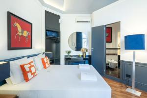 ナポリにあるLe Mummarelle Napoliのベッドルーム(オレンジ色の枕が付いた大きな白いベッド付)