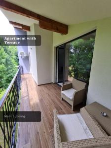 an apartment with a balcony with a table and chairs at Ilidža Park Apartments in Sarajevo