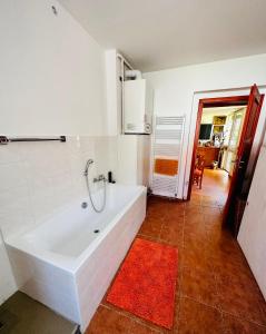 a white bath tub in a bathroom with a red rug at Malý penzion U Meruňky 