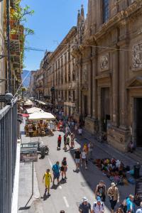 eine Gruppe von Menschen, die eine Stadtstraße entlang laufen in der Unterkunft Four Luxury Apartment in Palermo