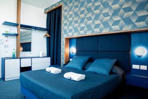 a bedroom with a blue bed with two towels on it at Al Chiar di Luna in Monte di Procida