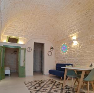 Habitación con pared de piedra, mesa y sillas. en Casa Munna, en Ceglie Messapica