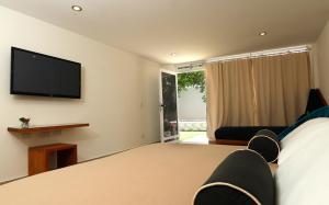 a bedroom with a bed and a flat screen tv at Posada Buena Vista Beach Club in El Yaque