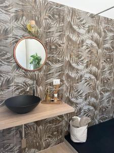 een badkamer met een wastafel en een spiegel aan een muur bij Sunset 221 Cagliari in Cagliari