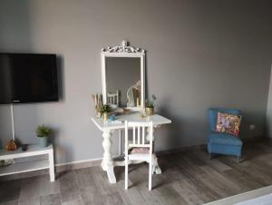 a white dressing table with a mirror and a blue chair at Benedettini House in Catania