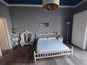 um quarto com uma cama branca e um espelho em Benedettini House em Catânia