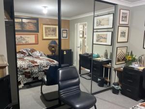 1 dormitorio con cama, escritorio y silla en Art House, en Huonville