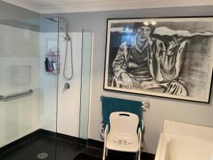 a bathroom with a painting of a man on the wall at Art House in Huonville