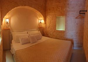 1 dormitorio con 1 cama en una pared de piedra en Casa Munna, en Ceglie Messapica