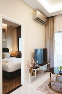 1 dormitorio con 1 cama, TV y mesa en THE NINE THASALA en Chiang Mai