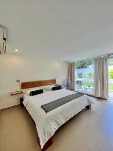 a bedroom with a large bed and a large window at Posada Buena Vista Beach Club in El Yaque