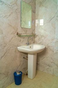 La salle de bains est pourvue d'un lavabo et d'un miroir mural. dans l'établissement Superbe appartement F4 à Dakar Mermoz-Sacré cœur, à Dakar