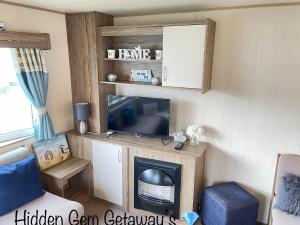a living room with a tv and a fireplace at Hidden Gem Getaways in Wyke Regis