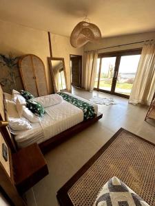 a bedroom with a bed and a large window at Hillside Chalet with panoramic views in Ambat