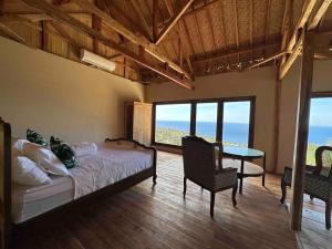 a bedroom with a bed and a table and chairs at Hillside Chalet with panoramic views in Ambat