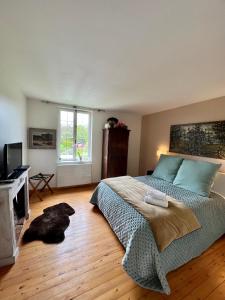 1 dormitorio con 1 cama grande y TV en Ailleurs sous les etoiles, en Manneville-la-Raoult