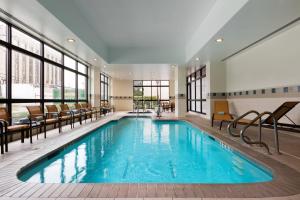 a large swimming pool with chairs and windows at Courtyard by Marriott Houston Galleria in Houston