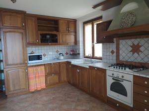 a kitchen with wooden cabinets and a stove top oven at APPARTAMENTO PIEVE ANTICA 