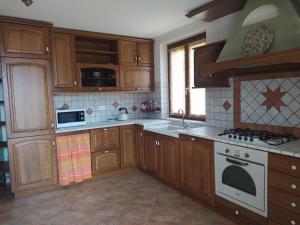 a kitchen with wooden cabinets and a stove top oven at APPARTAMENTO PIEVE ANTICA in Vilminore +6 photos