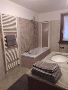 ein Badezimmer mit einer Badewanne, einem Waschbecken und einer Badewanne in der Unterkunft APPARTAMENTO PIEVE ANTICA 