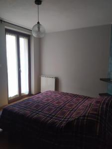 ein Schlafzimmer mit einem Bett mit einer lila Decke in der Unterkunft APPARTAMENTO PIEVE ANTICA 