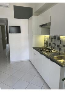 a white kitchen with a sink and a stove at Lingotto35 in Turin