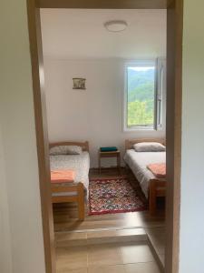 a bedroom with two beds and a window at Породично газдинство Вучићевић Porodično gazdinstvo Vučićević in Bačevci