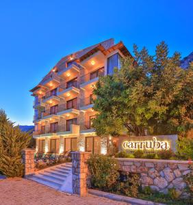 a building with a sign in front of it at Carruba Boutique Hotel in Kaş