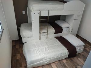 a room with three bunk beds and a couch at Villa Apart Center in Villa Constitución