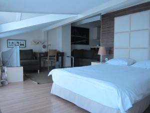 a bedroom with a large white bed and a living room at Derpa Hotel in Istanbul
