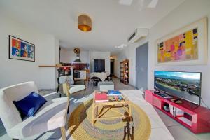 a living room with a large tv and a couch at La Terrasse - Apt T3 Saint Pierre in Saint-Pierre
